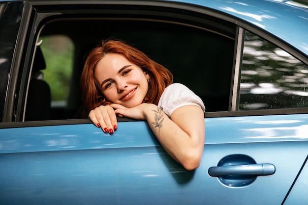 Portrait of of young woman looking at camera through window