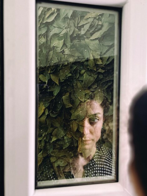 Foto ritratto di una giovane donna che guarda attraverso la finestra