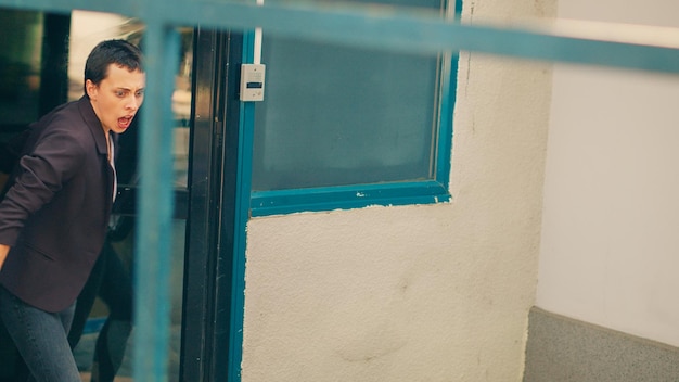 Photo portrait of young woman looking through window