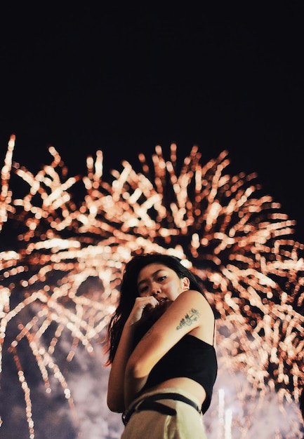 Photo portrait of young woman looking up at night