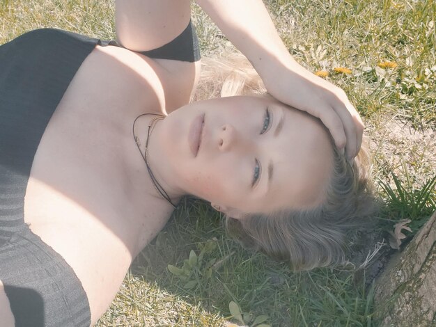 Portrait of young woman lying on field