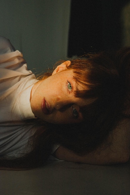 Portrait of young woman lying on floor at home