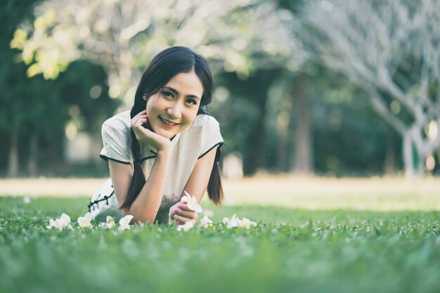 Portrait of young woman lying on grass in park