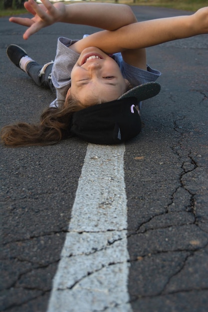 Photo portrait of young woman lying on road