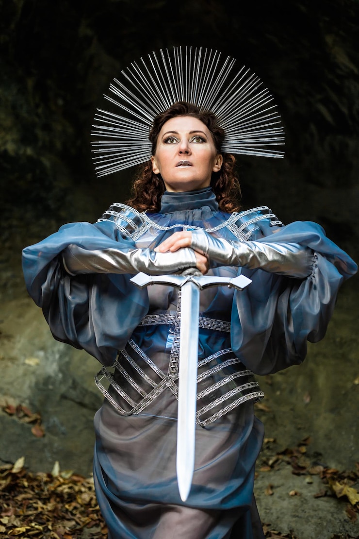 फोटो portrait of a young woman  medieval knight standing with a sword fantasy cosplay