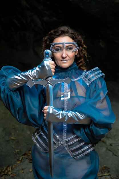 Photo portrait of a young woman  medieval knight standing with a sword fantasy cosplay