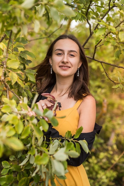 Portrait of young woman near autumn leaves in warm light