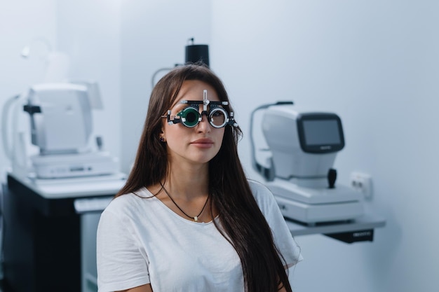 Портрет молодой женщины на приеме у окулиста Женщина в очках для проверки зрения