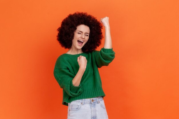 Portrait of young woman on orange background