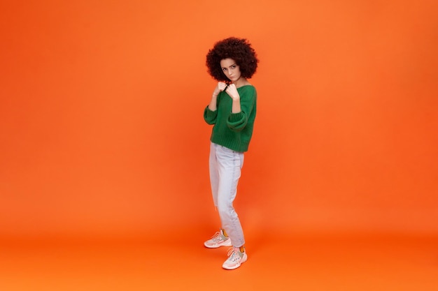 Portrait of young woman on orange background