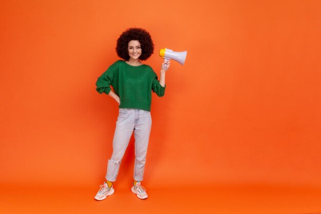 Portrait of young woman on orange background