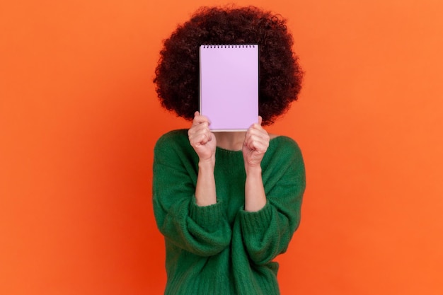 Portrait of young woman on orange background