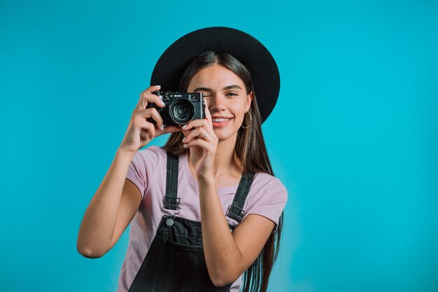 Foto ritratto di una giovane donna che fotografa contro il cielo blu