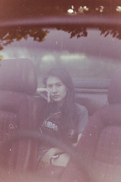 Photo portrait of young woman photographing in car