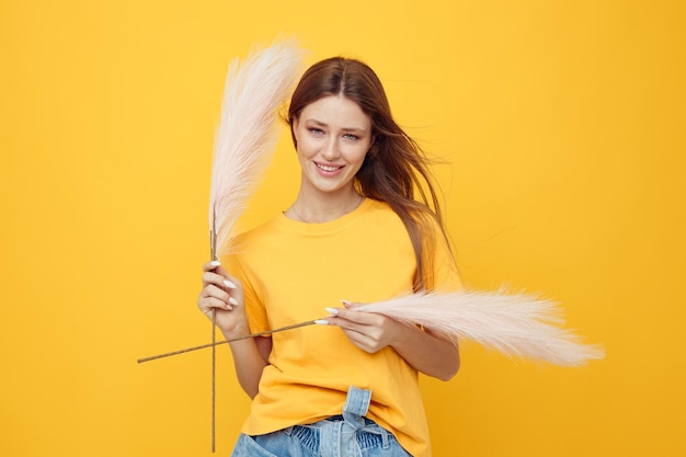 Portrait of a young woman pink feathers posing casual isolated background