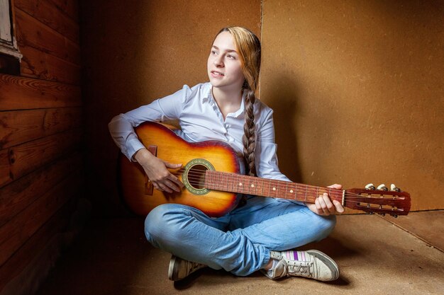 Portrait of young woman playing guitar