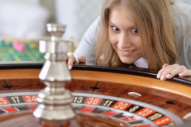 Photo portrait of a young woman playing roulette at casino