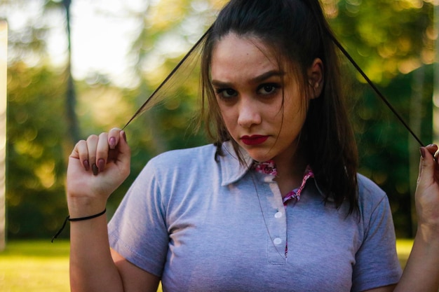 Foto ritratto di una giovane donna che gioca con i capelli al parco