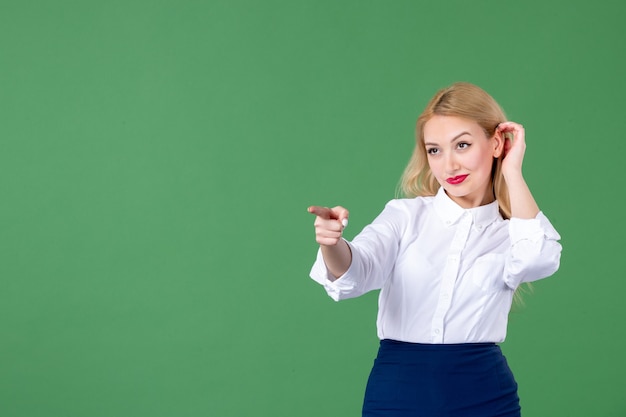 portrait of young woman pointing in green wall college book schools student teacher