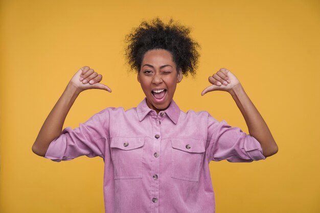 Photo portrait of a young woman pointing at herself