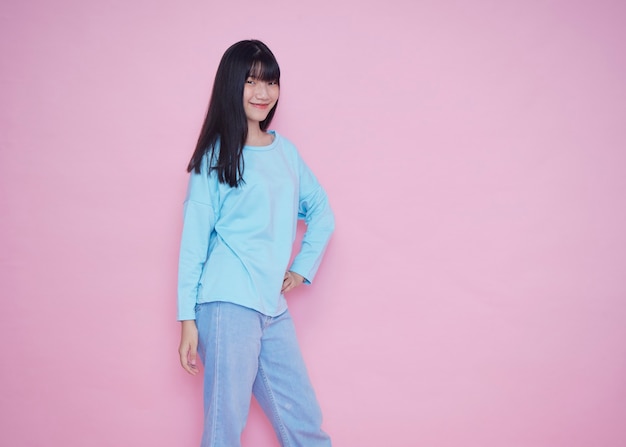 Portrait of young woman posing on pink wall