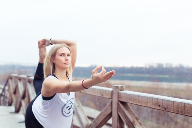 Foto ritratto di giovane donna che pratica posa yoga all'aperto sulla natura