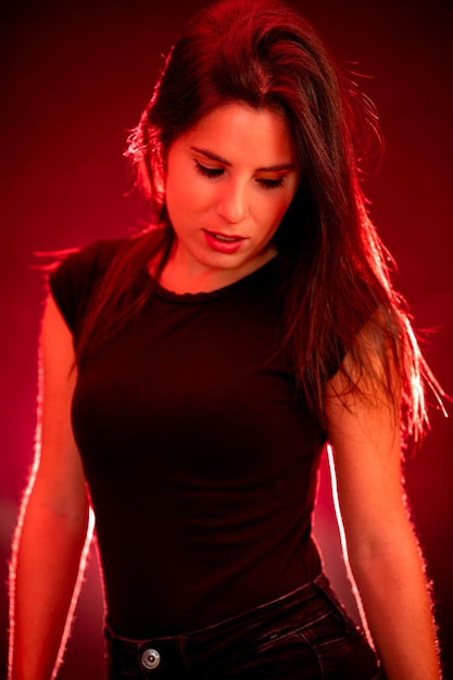 Portrait of a young woman on a red and black background with smoke