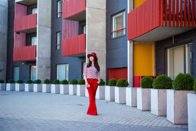 Foto ritratto di giovane donna in rosso che cammina per strada