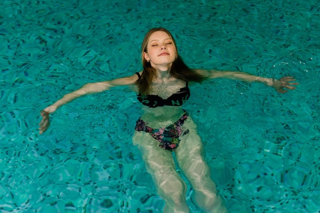 Portrait of young woman relaxing in a swimming pool