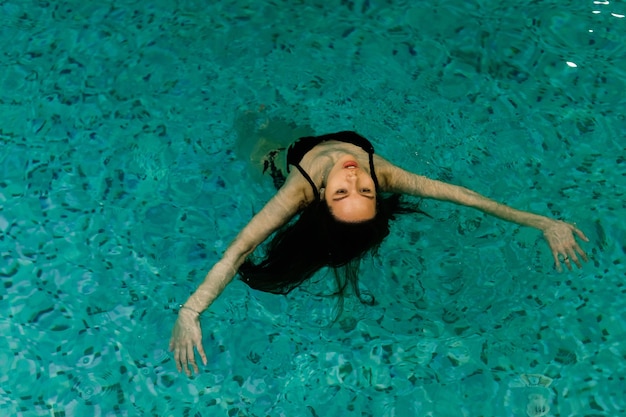 Portrait of young woman relaxing in swimming pool