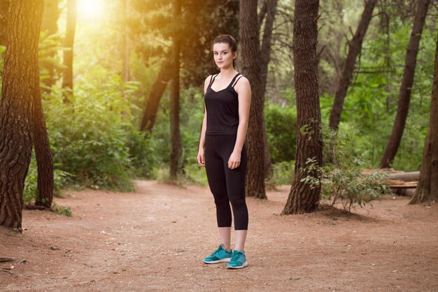 Portrait of a Young Woman Running In Wooded Forest Area  Training And Exercising For Trail Run Marathon Endurance  Fitness Healthy Lifestyle Concept