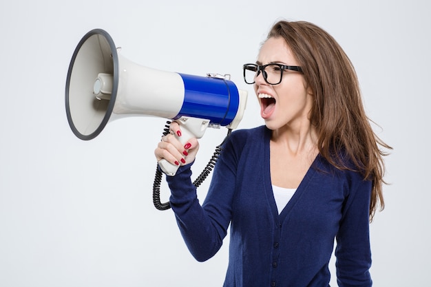 Portrait of a young woman screaming in megaphone isolated on a white background