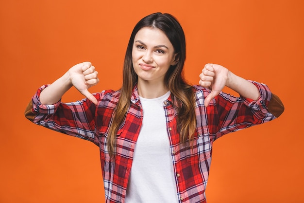 Photo portrait of a young woman showing thumbs down gesture