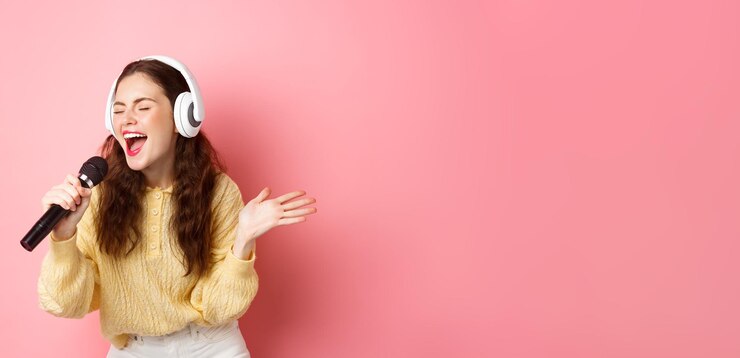 Photo ヘッドフォンを着用してカラオケを歌い、マイク st を保持している歌を演奏する若い女性の肖像画