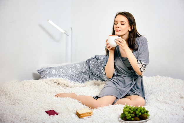 家のベッドに座っている若い女性の肖像画