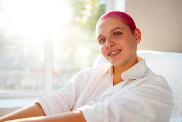 Photo portrait of young woman sitting on bed at home