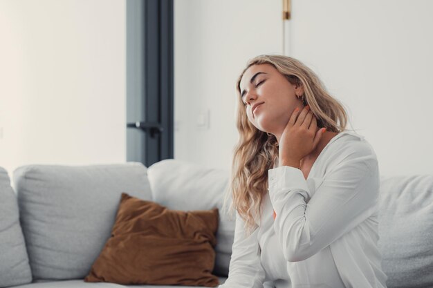 Portrait of young woman sitting on bed at home