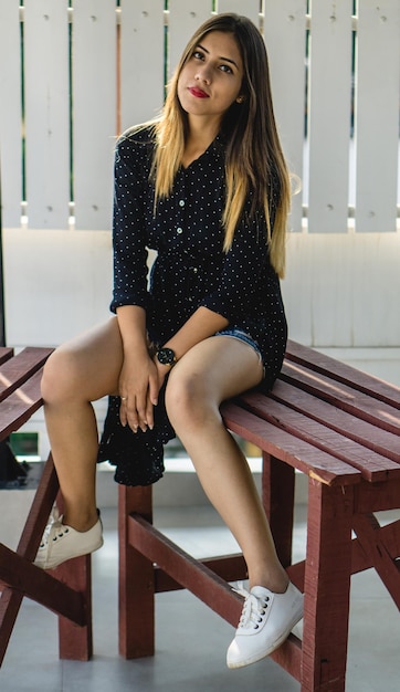 Photo portrait of young woman sitting on bench