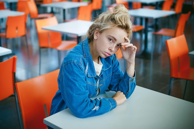 Photo portrait of young woman sitting at cafe