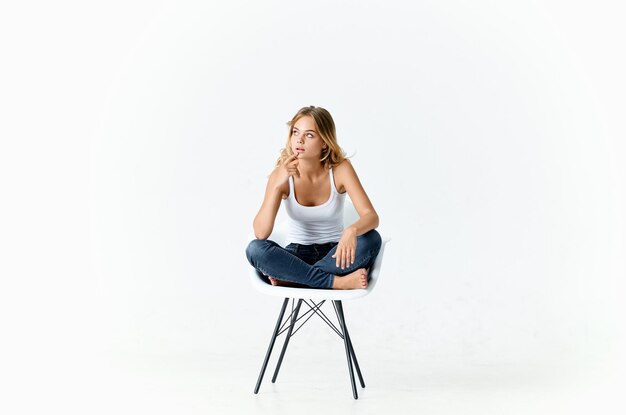 Photo portrait of young woman sitting on chair against white background