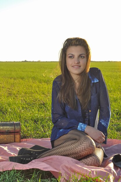 Photo portrait of young woman sitting on field