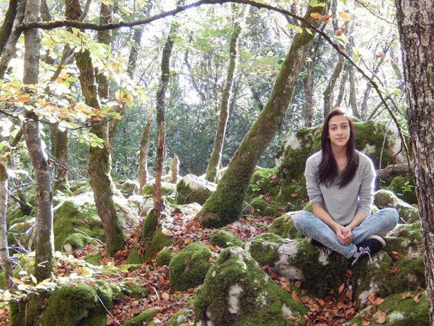 Foto ritratto di una giovane donna seduta nella foresta