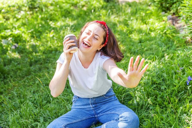 Photo portrait of young woman sitting on grassy field