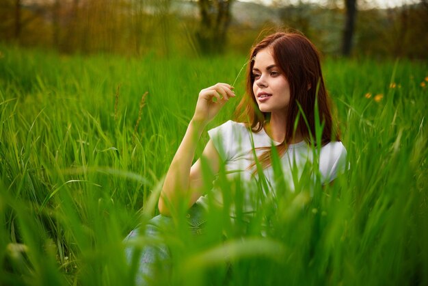 Foto ritratto di una giovane donna seduta su un campo erboso