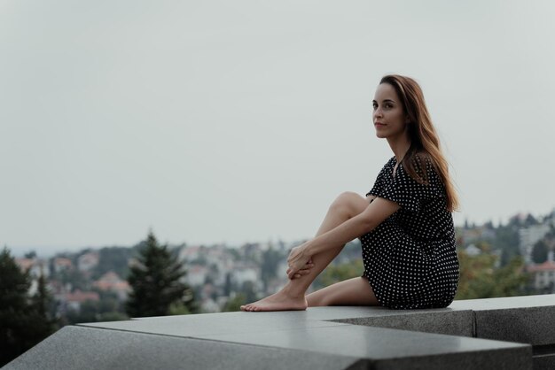 Photo portrait of young woman sitting on ledge