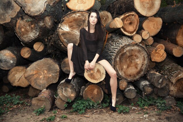 Photo portrait of young woman sitting on logs