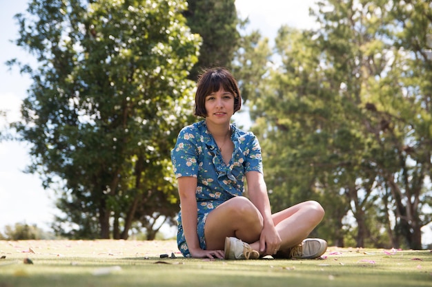 Photo portrait of young woman sitting in park