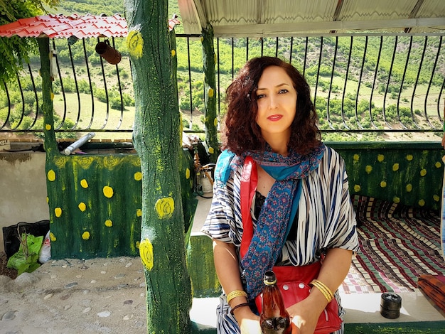 Photo portrait of young woman sitting on railing