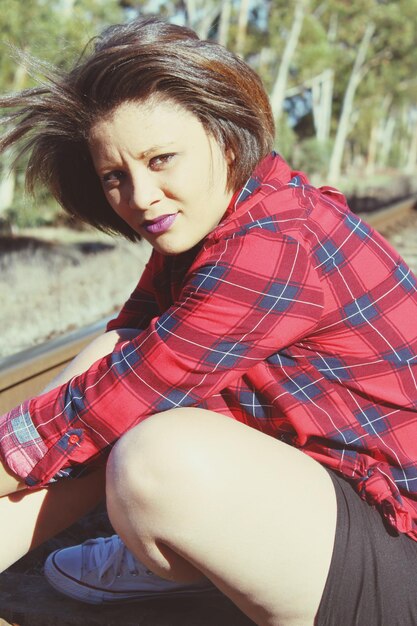 Photo portrait of young woman sitting on railroad track