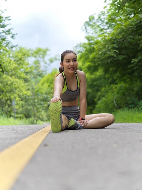 木に背を向けて道路に座っている若い女性の肖像画